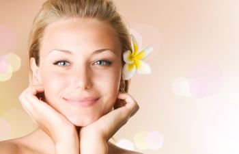 Face of a beautiful middle-aged woman with a flower in her hair.